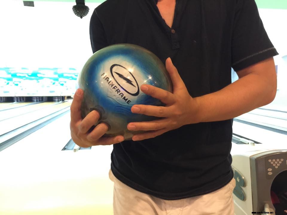come tenere una palla da bowling usando 2 mani per sostenerla il peso della palla 